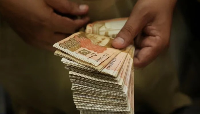 A trader counts Pakistani rupee notes at a currency exchange booth in Peshawar, Pakistan, July 29,2025. —Reuters