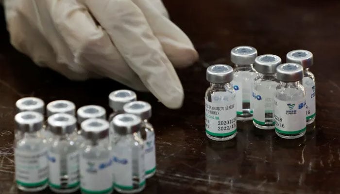 A health worker counts used vials of vaccine at a vaccination centre in Karachi. — Reuters/File