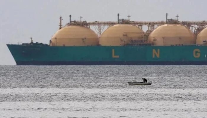This representational file photo shows a fisherman standing in his boat as a liquid natural gas tanker (LNG) passes the coast near Havana. — Reuters/File