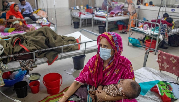 A woman holds a child diagnosed with measles inside a paediatric ward at the Bangladesh Shishu Hospital and Institute in Dhaka on May 6, 2026. — AFP