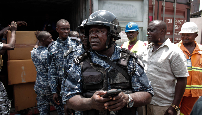 A member of the Transnational Organised Crime Unit (TOCU), a specialised unit of the Sierra Leone Police (SLP) dedicated to combating drug trafficking, organised crime and cross-border criminal activities, looks on after opening one of the four seized containers containing Tapentadadol (Tramadol) tablets and capsules originating from India at the Freetown Terminal in Freetown, on March 27, 2026. — AFP