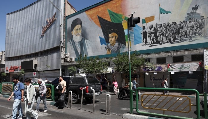 People walk past a mural depicting Irans late Supreme Leader Ayatollah Ali Khamenei and the late leader of the Islamic Revolution, Ayatollah Ruhollah Khomeini (not pictured), in Tehran, Iran, May 25, 2026. — Reuters