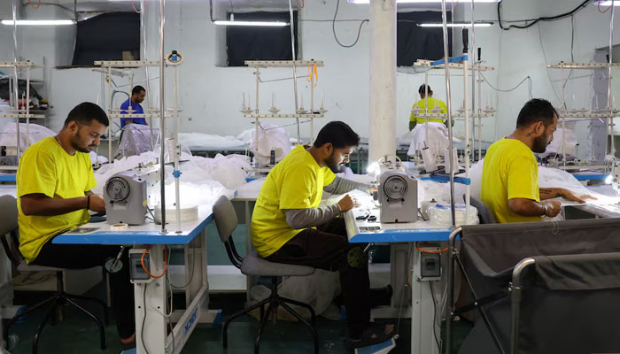 A representational image of workers in a garment factory stitching clothes. — Reuters/File