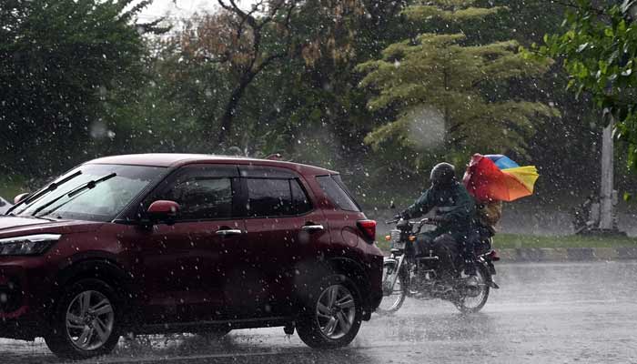 Vehicles pass through heavy rain on the Expressway in the federal capital.— APP/File