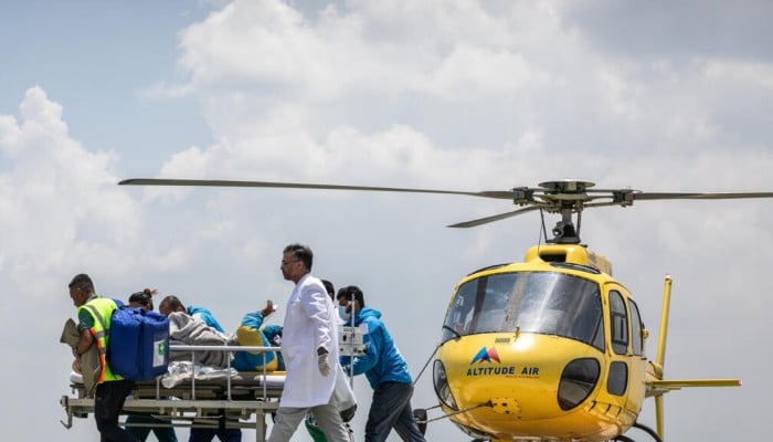 Medics and rescuers transfer mountaineer Dawa Sherpa from a helicopter upon his arrival at the HAMS Hospital in Kathmandu on June 4, 2026. — AFP