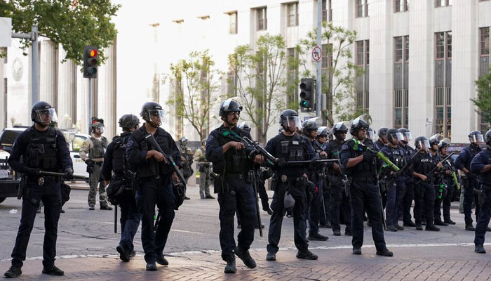 Members of law enforcement stand guard as people protest against federal immigration sweeps, in downtown Los Angeles, California, US. — Reuters/File