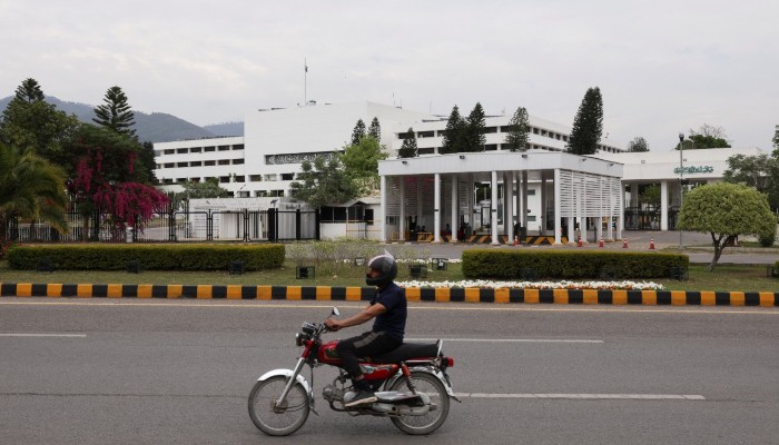 A man on a motorbike rides past the Parliament House building in Islamabad, March 28, 2026. — Reuters