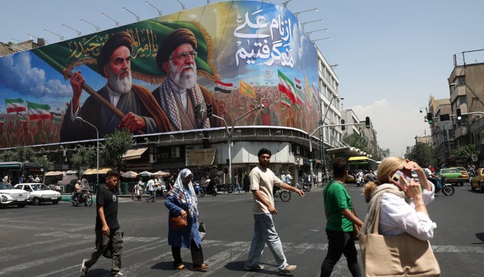 People walk past a billboard depicting the late leader of the Islamic Revolution, Ayatollah Ruhollah Khomeini, and the late Irans Supreme Leader Ayatollah Ali Khamenei, on a street in Tehran, Iran, June 6, 2026. — Reuters