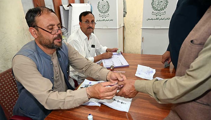 An election official applies ink on a voters thumb at a polling station during the Gilgit-Baltistan General Elections 2026. — APP