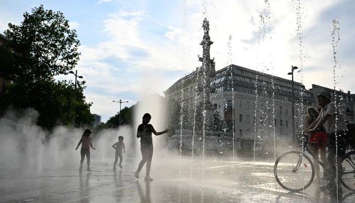 People cool off under a water sprinkler during a heat wave in Vienna, Austria, August 14, 2024. — Reuters