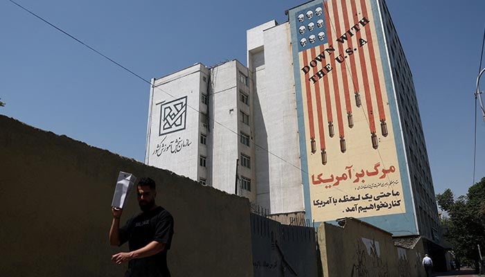 A man walks near an anti-US mural on a building in Tehran, Iran, June 9, 2026. — Reuters