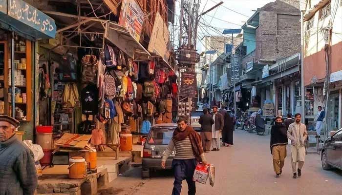 Local residents walking across a market in Parachinar on December 3, 2024. — AFP