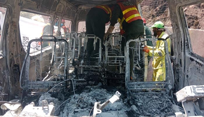 Rescue workers inspect the burnt-out tourist van involved in the deadly crash near Khajut on Islamabad-Murree Expressway, Murree, June 10, 2026. — Reporter