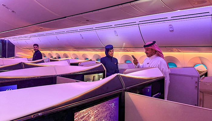 A man speaks with a hostess aboard a Boeing 787-9 Dreamliner aircraft of Saudi airline Riyadh Air at King Khalid International Airport in Riyadh on June 7, 2026. — AFP