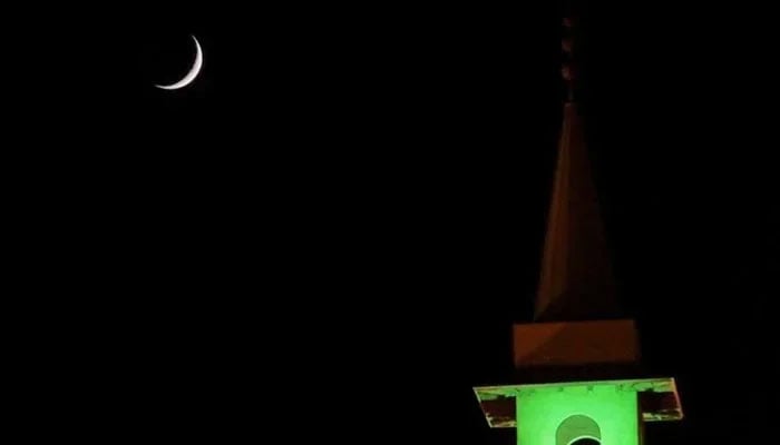 A crescent is seen on the dark sky in the background of a minaret in this undated image. — Reuters/File