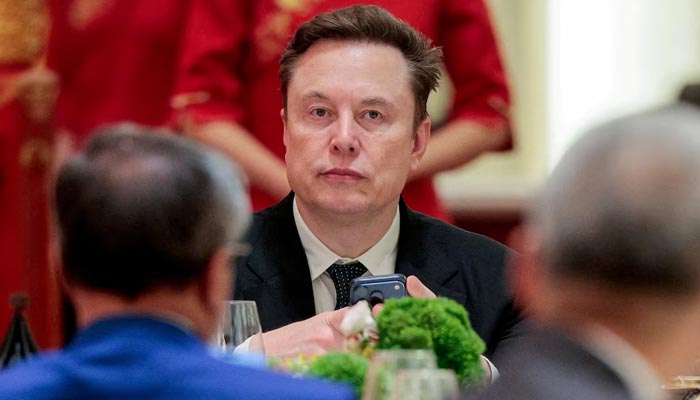 Space X CEO Elon Musk holds a mobile phone as he arrives to attend a state banquet with US President Donald Trump and Chinese President Xi Jinping at the Great Hall of the People in Beijing, China, May 14, 2026. — Reuters