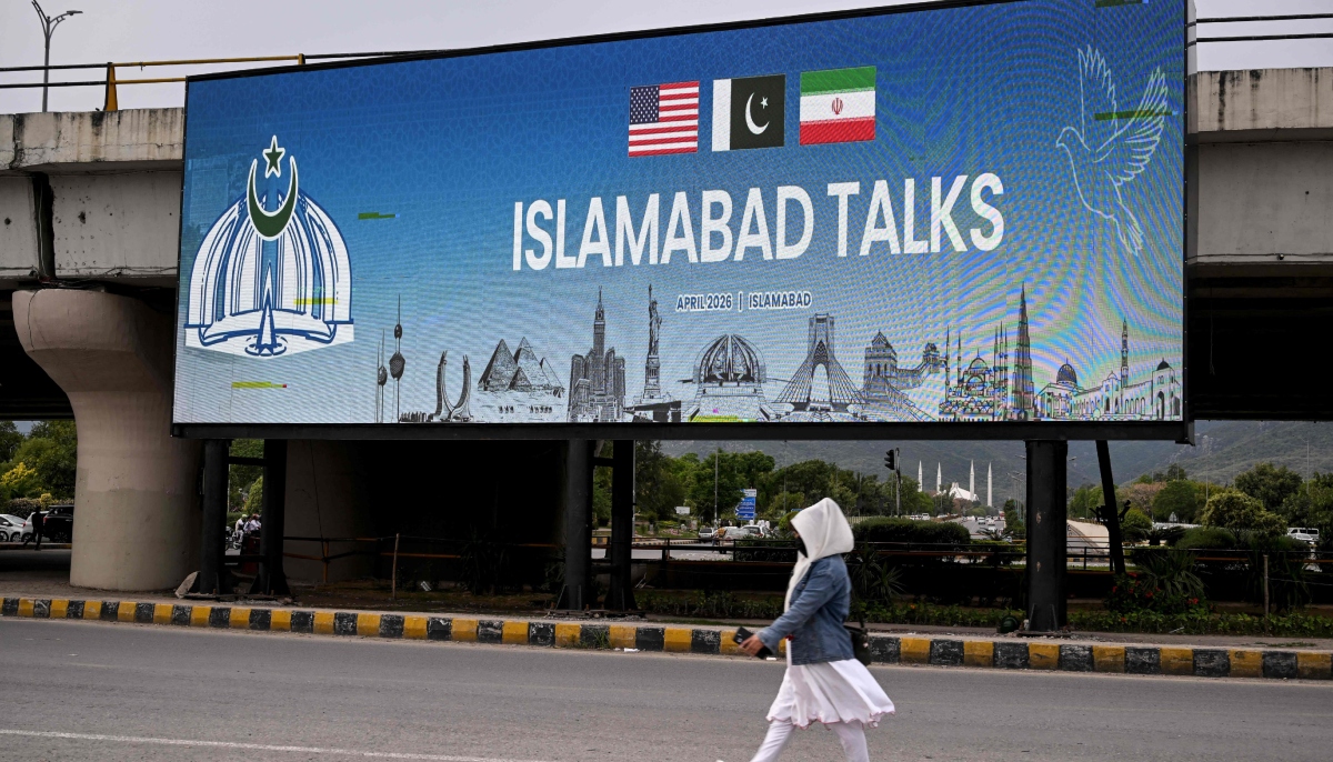 On April 8, 2026 Pakistan announced that the US and Iran had agreed to an immediate ceasefire and both parties to hold talks in Islamabad. In this picture, a woman walks past a digital screen displaying news of US-Iran peace talks along a road in Islamabad on April 10, 2026. — AFP