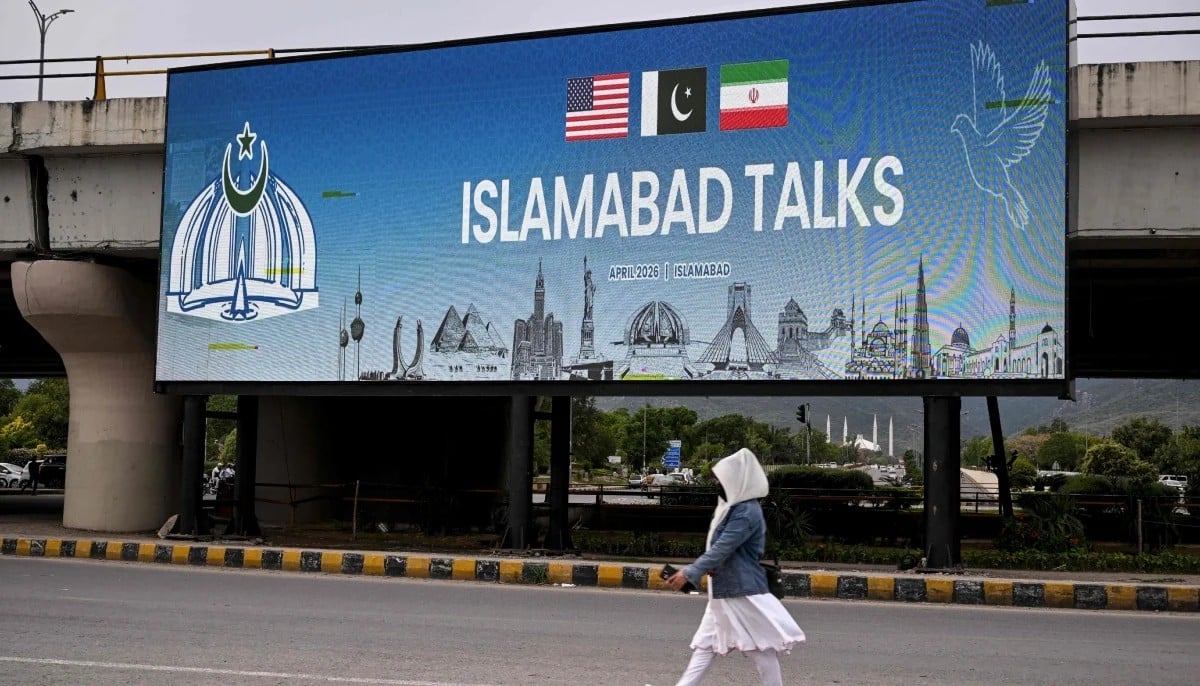 On April 8, 2026 Pakistan announced that the US and Iran had agreed to an immediate ceasefire and both parties to hold talks in Islamabad. In this picture, a woman walks past a digital screen displaying news of USâ€“Iran peace talks along a road in Islamabad on April 10, 2026. — AFP