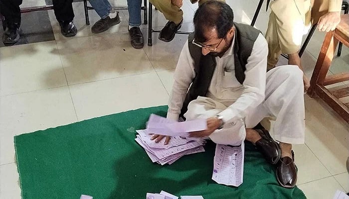 Election official counts votes at a polling station during final phase of GB General Elections 2026. — APP/File