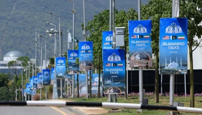Hoardings are mounted on lamp posts, as Pakistan prepares to host the US and Iran for a possible second phase of talks in Islamabad, April 20, 2026. — Reuters