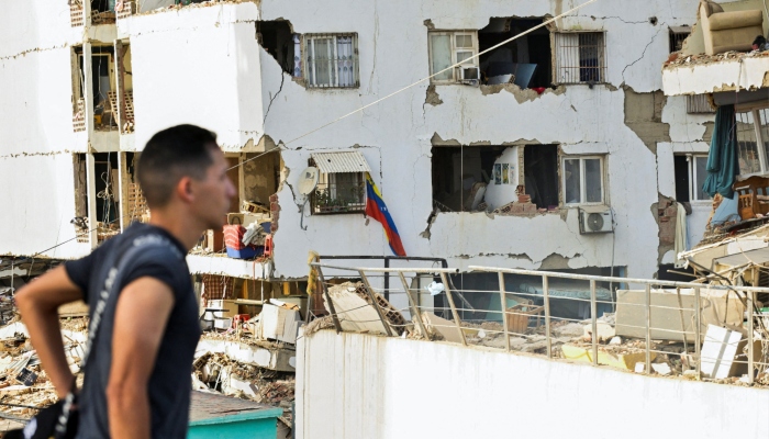 A man walks past damaged buildings in the aftermath of earthquakes in La Guaira, Venezuela, June 25, 2026. — Reuters