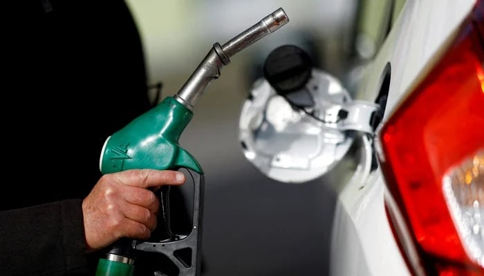A man holds a fuel nozzle at a petrol station in Reze, near Nantes, France, March 18, 2022. — Reuters