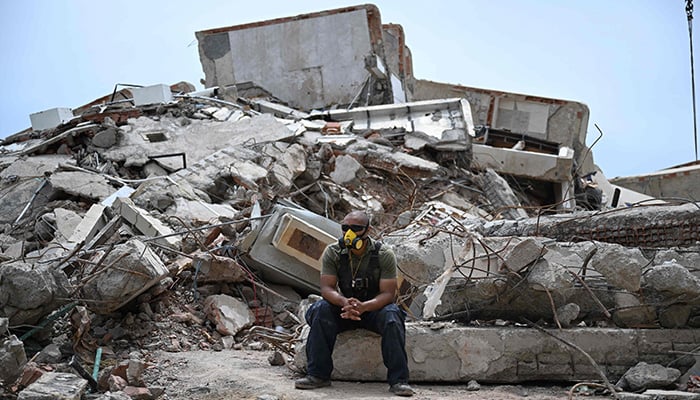 A volunteer rests next to rubble in La Guaira, Venezuela on July 4, 2026, following the June 24 twin earthquakes. — AFP