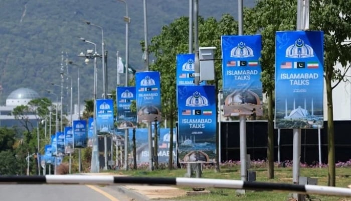 Hoardings are mounted on lamp posts, as Pakistan prepares to host the US and Iran for a possible second phase of talks in Islamabad, April 20, 2026. — Reuters