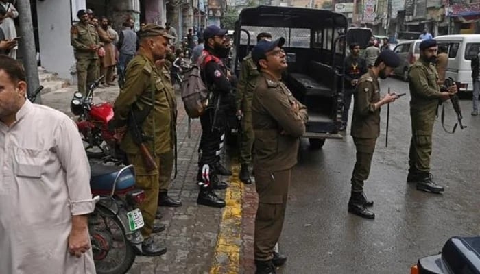 Police personnel patrol a market in Lahore. — APP/File