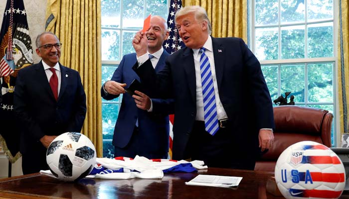 US President Donald Trump holds up a red card as he meets with Fifa President Gianni Infantino in the Oval Office of the White House in Washington, US, August 28, 2018. — Reuters