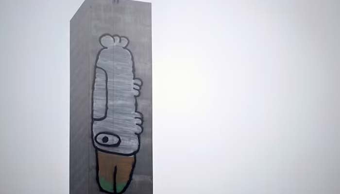 A man sits atop the eastern pylon of the Bolte Bridge above a graffiti tag often associated with Pam the Bird in Melbourne, Australia, July 7, 2026. — Reuters