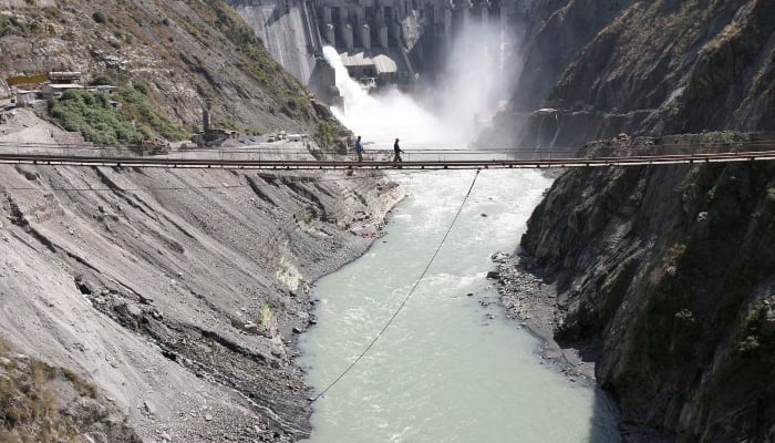 Labourers walk on a bridge near the 450-megawatt hydropower project located at Baglihar Dam on the Chenab river, at Chanderkote, about 145 km (90 miles) north of Jammu October 10, 2008. — Reuters