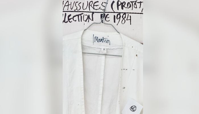 This photograph shows Martin Margiela´s personal white coat with his name written inside during an exhibition at the Quartier General in Paris on July 7, 2026. — AFP
