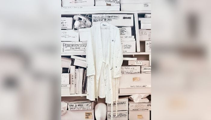 This photograph shows Martin Margiela´s personal white coat with his name written inside during an exhibition at the Quartier General in Paris on July 7, 2026. — AFP