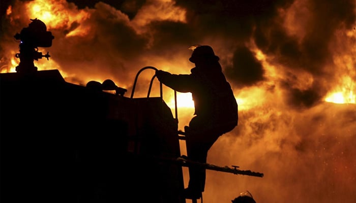 A firefighter climbs onto a fire truck as he and his colleagues try to extinguish a fire at a petrochemical plant in Zhangzhou, Fujian province. — Reuters/File