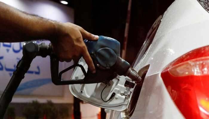 A worker holds a fuel nozzle to fill a car with fuel at a petrol station in Karachi on September 16, 2023. — Reuters