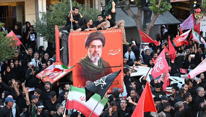 Crowds gather on a street around a portrait of Irans supreme leader Mojtaba Khamenei at the Shrine of Imam Reza, Irans most revered place of worship, in Mashhad on July 9, 2026. — AFP