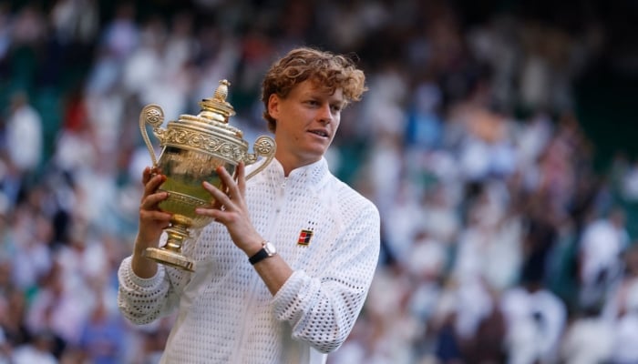 Italys Jannik Sinner celebrates with the trophy after winning his final match against Germanys Alexander Zverev on July 12, 2026. — Reuters