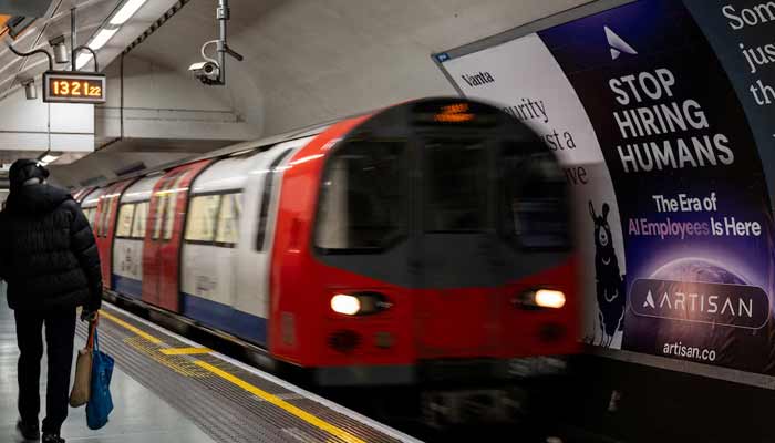A person passes a billboard for an Artificial Intelligence company advertising on a London underground station platform in London, Britain, June 5, 2025. — Reuters