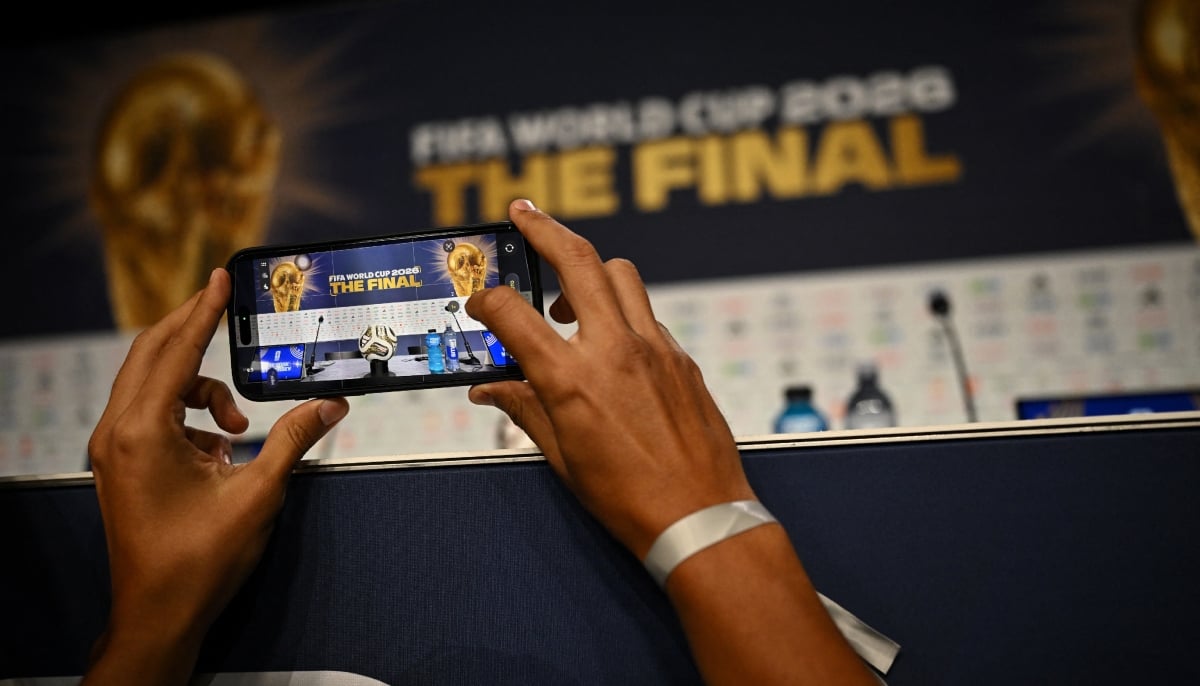 A journalist takes a picture of the official match ball for the final of the FIFA World Cup before the press conference on July 17, 2026. — Reuters