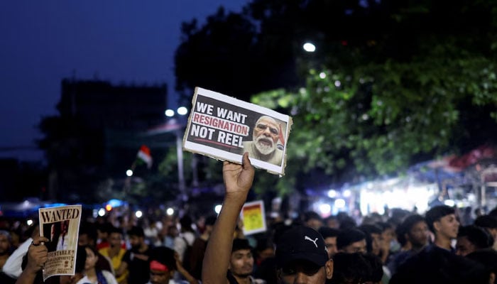 A man holds a poster as he participates in a demonstration held in solidarity with Cockroach Janta Party (CJP) protests held at Jantar Mantar in New Delhi, which demand the resignation of Indias Education Minister Dharmendra Pradhan over exam paper leaks, in Kolkata, India, July 24, 2026