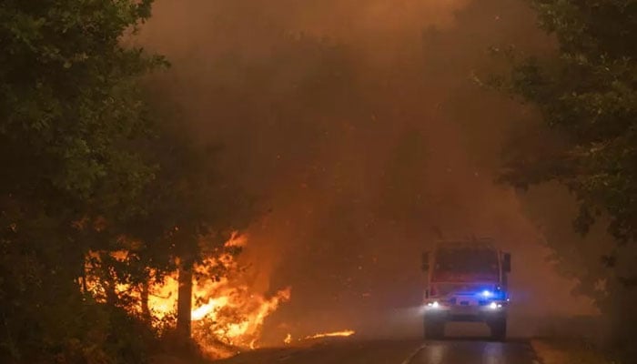 This handout photograph taken on July 24, 2026 shows French firefighters trying to extinguish the wildfire near Saumos and Sainte-Helene, northwest of Bordeaux, in the Gironde department. — AFP