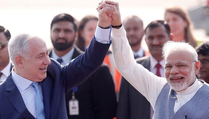 Israeli Prime Minister Benjamin Netanyahu and his Indian counterpart Narendra Modi raise their arms upon Netanyahu’s arrival at Air Force Station Palam in New Delhi, India, January 14, 2018.