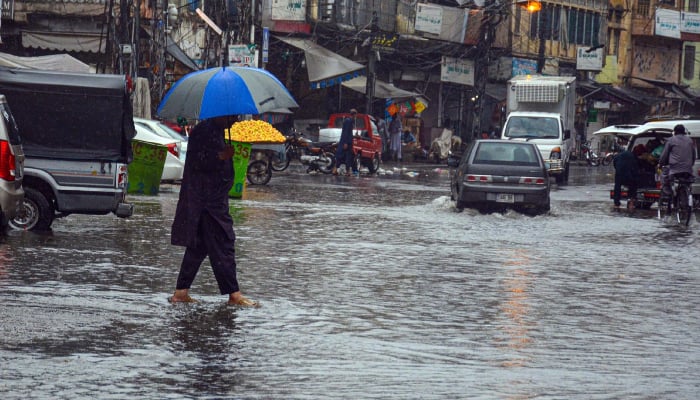 A man on the way hold umbrella during rain in Rawalpindi, July 31, 2026. — INP