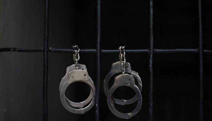 Handcuffs can be seen on a jail cells bars. — Reuters/File
