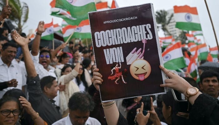 A protester holding a placard celebrates the resignation of Indias Education Minister Dharmendra Pradhan in Mumbai, India, July 25, 2026. — AFP