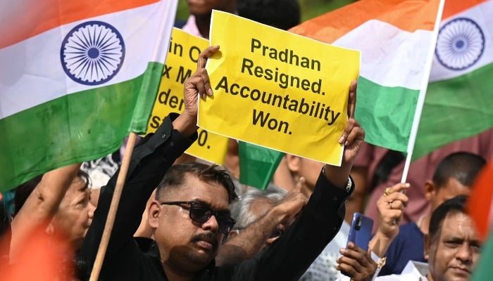Protesters holding posters celebrate the resignation of India´s Education Minister Dharmendra Pradhan in Mumbai on July 25, 2026. — AFP