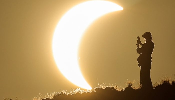 A person takes a picture as the moon partially covers the sun during a total solar eclipse as seen from the Javalambre Astrophysical Observatory in Arcos de las Salinas, near Teruel, Spain, August 12, 2026. — Reuters