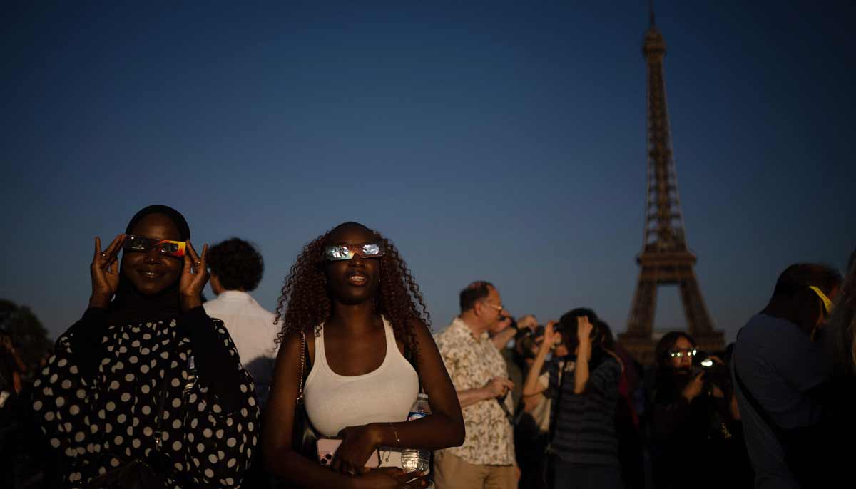 People wearing solar eclipse viewing glasses look at a partial solar eclipse from the Trocadero squa. — AFP
