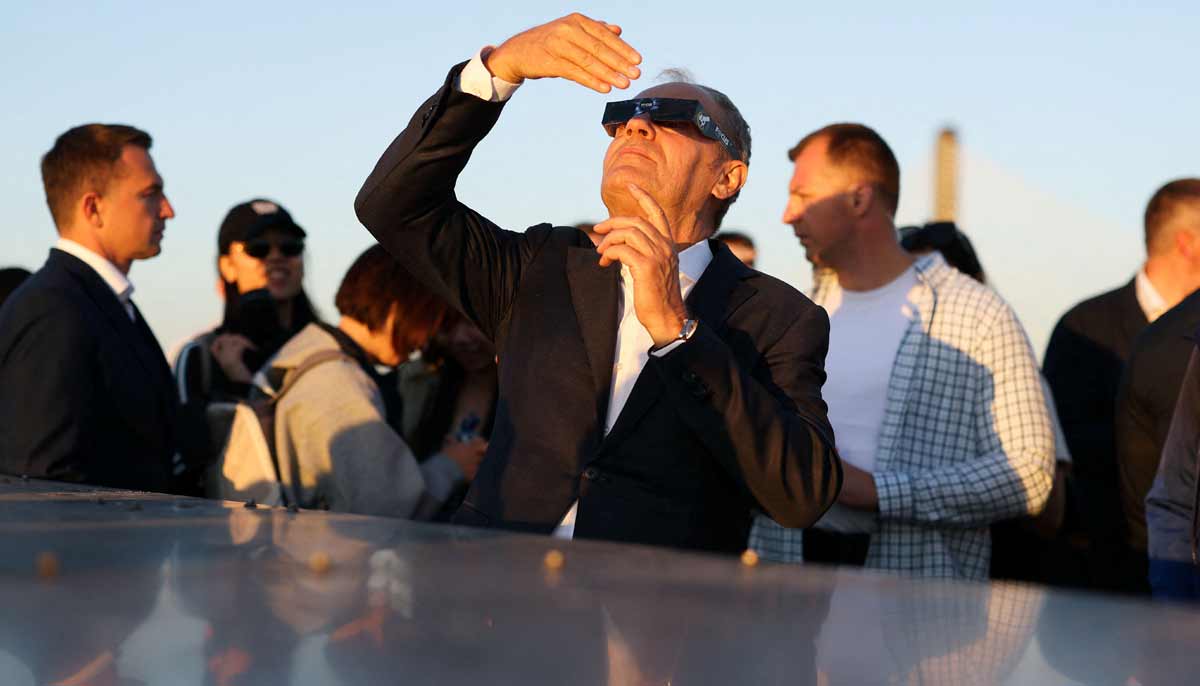 Polish Prime Minister Donald Tusk looks at the sun through the special protective glasses during partial solar eclipse, at the Copernicus Science Centre in Warsaw, Poland, August 12, 2026.— Reuters